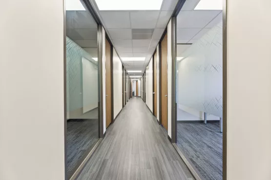 Long office hallway with wood doors and gray carpet