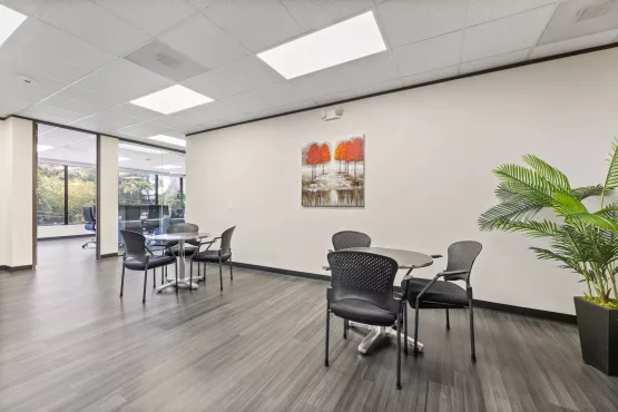 Office break area with tables, chairs, and wall art
