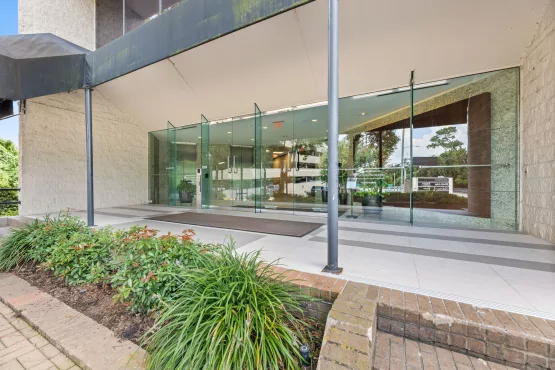 Glass front entrance of office building with covered walkway