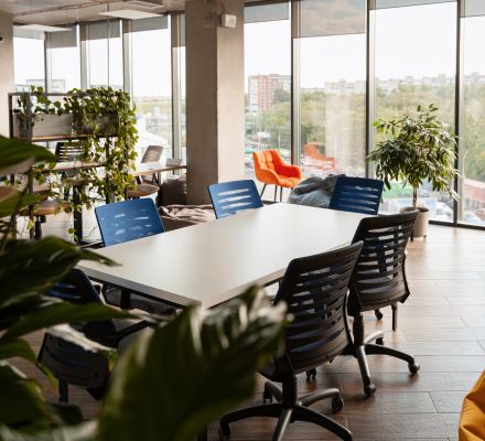 Bright coworking area with a meeting table and large windows overlooking the city.